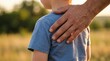 © Margarita - Adult hand resting on child's shoulder in a sunlit field