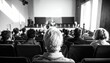 © HartaDwi - Attentive audience members viewed from behind, engaged in a professional conference presentation within a dimly lit auditorium, captured in classic monochrome