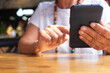 © luciano - Close up of senior woman's hands using smartphone typing message while enjoying  a break at coffee shop in mall