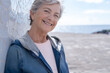 © luciano - Portrait of attractive smiling gray haired senior woman in outdoor standing looking at camera. Relaxed grandmother enjoying good time and retirement. White background