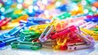 © Kitiphong - A photo of colorful plastic clips scattered on a pristine white background, each clip in vibrant hues with smooth edges and glossy surfaces