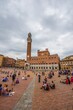 © Moritz Wolf/imageBROKER - Tourists at the Palazzo Pubblico with Mangia Tower and Chapel, Piazza Il Campo, Siena, Tuscany, Italy