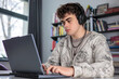 © Светлана Мищенко - High school student preparing for exams using laptop and books. Teenager studying at desk with laptop, modern education concept