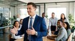 © Svitlana - A self-assured young business executive standing in front of his attentive co-workers in a bright modern office, speaking confidently with open gestures, dressed in a sharp formal suit with a