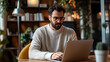 © BURINKUL - A focused man works on a laptop in a cozy indoor environment, embodying productivity and modern workplace culture.