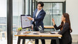 © David - Confident Asian Businessman Explaining Data on Monitor to Female Colleague.Two business reading Planning analyze marketing infographic.
