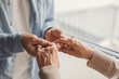 © Daniel - An elderly couple gently holding hands in a close-up moment of tenderness and support, conveying love, connection, care and lifelong companionship in a warm, intimate home setting
