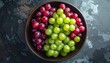 © Awan - Fresh grapes of various colors arranged beautifully in a bowl. The grapes include green and red varieties, presented in an overhead shot