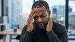 © Mofulume - Stressed black man suffering from severe headache and neck pain in office