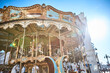 © Namsun - Colorful carousel in a European city square lit by bright afternoon sun