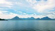 © Gianti - A tranquille view of serene lake surrounded by mountains and beautifull  blue sky and cloud.