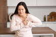 © Pixel-Shot - Young woman having heart attack in kitchen