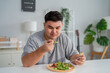 © Kawee - Asian young plus-size man enjoy eating favorite healthy salad in house.