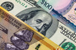 © Sergii - Different 100 Dollars banknotes from the USA, Guyana, and Zimbabwe. Global variety of the dollar as a monetary unit.