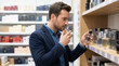 © Vera - Young man selecting cologne in store and smelling fragrance bottles