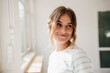 © Westend61 - Smiling woman in striped shirt at creative studio with natural light