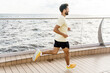 © muse studio - Fitness focused man running on a modern cruise ship deck beside the sea under blue sky
