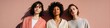 © Andrii Zastrozhnov - Three adult female models caucasian african caucasian standing in sunlight against peach wall wearing light jackets and neutral tones