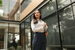 © Parichat - Young businesswoman looking confidently holding laptop outdoors