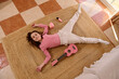 © Taras Grebinets - Smiling Girl Lying on Rug with Pink Ukulele and Headphones Relaxing at Home
