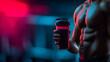 © KotBaton - Muscular man holding protein shake in gym, fitness and sports nutrition concept.