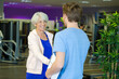 © auremar - man with clipboard greeting woman at fitness center