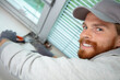 © auremar - workman using pliers by a window