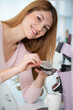 © auremar - woman using coffee capsule machine in kitchen