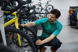 Skilled male technician thoroughly inspects bicycle wheel quality