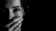 © IrinZatsepina - close up black and white portrait of woman covering mouth with hand looking at camera strong shadow and large copy space concept of fear anxiety silence and mental health awareness