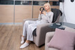 © lara-sh - Sound Relaxation. Female resting in chair wearing black headphones enjoying music at home quiet domestic atmosphere comfort moment.