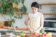 © buritora - A young Asian woman cooking in the kitchen (cutting, using a knife, cooking, home-cooked meal)