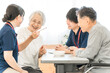 © buritora - Female patients and male and female caregivers performing bean-grabbing exercises at nursing homes, hospitals, and rehabilitation centers.