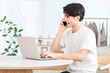 © buritora - Japanese man working remotely from home, making a phone call on his smartphone (side job, meeting, working from home)