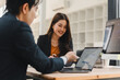 © PRIME STOCK LAB - Asian business professionals collaborating on a project using a laptop in a modern office