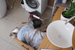 © Pixel-Shot - Female plumber fixing sink in bathroom, top view