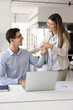 © fizkes - Young businesswoman and male colleague share fist bump gesture, accomplish teamwork, encouraging each other before important meeting, relish joint professional success. Positive workplace relationship