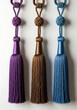 © Rokon - Three colorful tassels hanging on a white wall with shadows