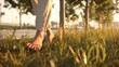 © santima - Barefoot walking on grass in warm sunlight.