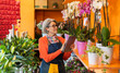 © Westend61 - Florist in apron using tablet while organizing plants in flower shop