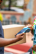 © Roger - Delivery man holding a package and pos terminal, receiving a contactless payment from a customer