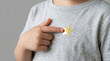 © Sana Sabina - Child pointing at gold star badge on gray shirt background