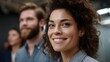 © Thares2020 - A smiling professional woman in focus with colleagues in a modern office symbolizing teamwork and success