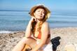© SISMIZ - Woman applying sunscreen to face enjoying beach vacation