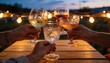 © SERHII - Group of friends clinking crystal glasses in a toast. People celebrating with wine and drinks at an outdoor evening party. Warm string lights bokeh background on a wooden table at dusk