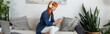 © LIGHTFIELD STUDIOS - Young woman with red hair enjoys leisure time in a stylish modern living room