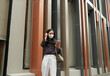 © PaeGAG - Young woman wearing face mask checking phone in city