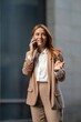 © Zoran Jesic - Businesswoman talking on phone outside office building