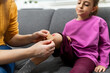 © zphoto83 - Mother applying adhesive bandage to little girl bruised knee at home