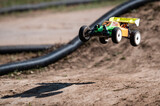 Radio-controlled car jumping on dirt track
